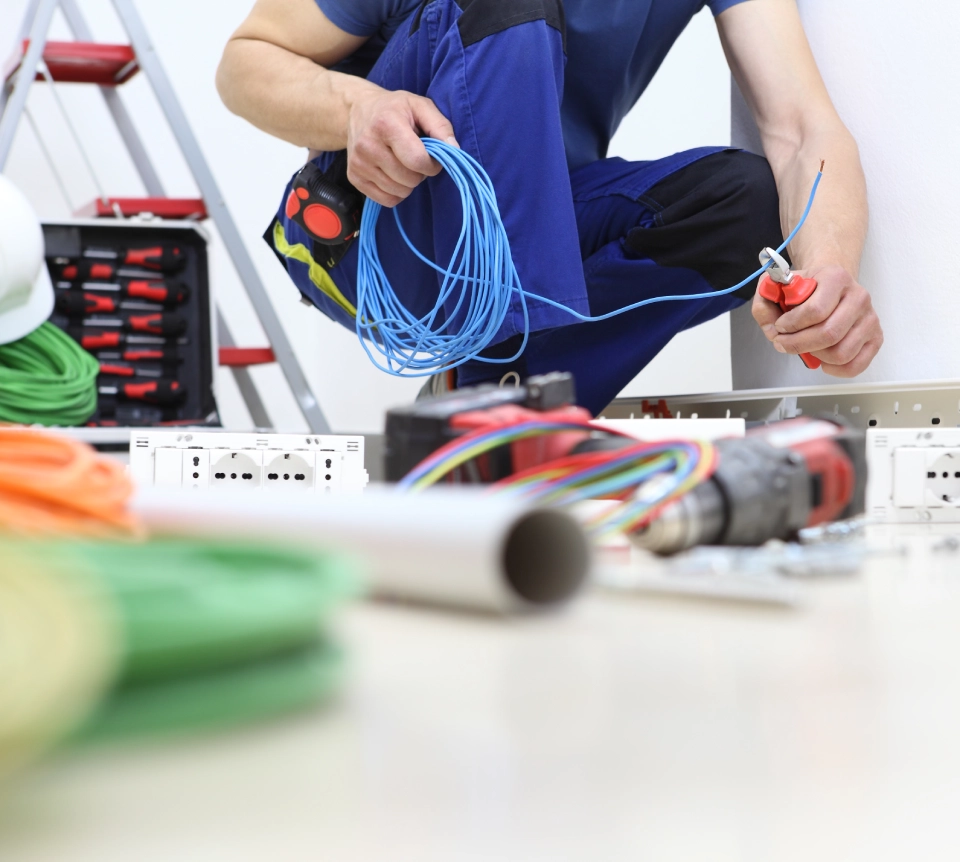 Elektriker hanterar blå kabel på golv